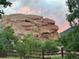 Scenic landscape with a large rock formation, trees, and a rustic fence at 6227 Colorow Dr, Morrison, CO 80465