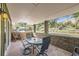 Covered outdoor patio area with a dining table and beautiful views of the landscaped yard at 6227 Colorow Dr, Morrison, CO 80465