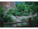 Two fawns in wooded area with a rustic wooden fence at 6227 Colorow Dr, Morrison, CO 80465