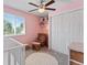 Charming bedroom with pink walls, a ceiling fan, a window, and closet space, perfect for a comfortable Bedroom at 17411 E Layton Dr, Aurora, CO 80015