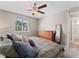 Well-lit bedroom with a ceiling fan, window, and wooden dresser, offering a serene and organized living space at 17411 E Layton Dr, Aurora, CO 80015
