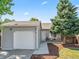 Charming home featuring a well-manicured lawn and an attached garage with a quaint outdoor seating area at 17411 E Layton Dr, Aurora, CO 80015