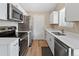 Modern kitchen featuring stainless steel appliances, white cabinets, and sleek countertops at 17411 E Layton Dr, Aurora, CO 80015