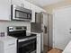 Modern kitchen with stainless steel appliances, including a microwave, oven, and refrigerator at 17411 E Layton Dr, Aurora, CO 80015