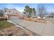 View of front exterior showcasing long driveway, brick, and garage of this lovely home at 1431 E Long Pl, Centennial, CO 80122