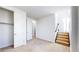 Bright bedroom features neutral carpet, closet and an entry door, plus access to staircase at 1937 S Columbine St, Denver, CO 80210