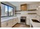 Sleek, modern kitchen with stainless steel appliances, geometric backsplash and floating wood shelves at 1937 S Columbine St, Denver, CO 80210