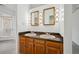 Bathroom featuring a double sink vanity with wood cabinets, framed mirrors, and decorative sconces at 6700 W 11Th Ave # 202, Lakewood, CO 80214