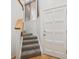 Stairwell featuring carpeted steps, and light walls, adjacent to a door and window providing natural light at 6700 W 11Th Ave # 202, Lakewood, CO 80214