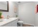 Well-lit half bathroom with modern sink, white toilet, and stylish decor at 4262 E Maplewood Way, Centennial, CO 80121