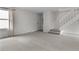 Bright, carpeted living area with staircase and access to the front door at 4262 E Maplewood Way, Centennial, CO 80121