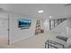 Finished basement with neutral carpet, a television mounted to the wall, and a staircase leading upstairs at 6987 E Wyoming Pl, Denver, CO 80224