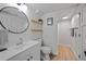 Bright bathroom featuring a modern sink, round mirror and a shower at 6987 E Wyoming Pl, Denver, CO 80224