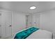 Bright bedroom with white walls and trim featuring a turquoise throw and plenty of natural light at 6987 E Wyoming Pl, Denver, CO 80224