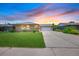Charming single-story home featuring a well-maintained lawn and a spacious driveway leading to a two-car garage at 6987 E Wyoming Pl, Denver, CO 80224