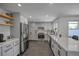 Sleek kitchen featuring gray cabinets, stainless steel appliances, stylish countertops, and an open design at 6987 E Wyoming Pl, Denver, CO 80224