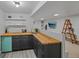 Modern kitchenette area featuring butcher block counters, gray cabinets, and floating shelves in a finished basement at 6987 E Wyoming Pl, Denver, CO 80224