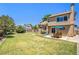 An expansive backyard offers a patio, lush grass, and mature trees, perfect for entertaining at 5310 E Manchester Dr, Castle Rock, CO 80104