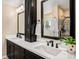 A modern bathroom features a dual sink vanity with black cabinets, quartz countertops, and framed mirrors at 5310 E Manchester Dr, Castle Rock, CO 80104