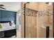 A modern tiled shower provides a refreshing retreat, with a blue bedroom peeking in the background at 5310 E Manchester Dr, Castle Rock, CO 80104