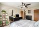A spacious main bedroom features a ceiling fan, black dresser, and access to the ensuite bathroom at 5310 E Manchester Dr, Castle Rock, CO 80104