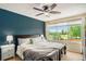 Serene bedroom with a calming blue accent wall, large window and a comfortable bed at 5310 E Manchester Dr, Castle Rock, CO 80104