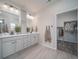 Well-lit bathroom featuring double vanity sinks, granite countertops, and easy access to the walk-in closet at 21935 E 51St Dr, Aurora, CO 80019