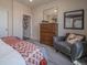 Serene main bedroom with a dresser, gray chair, and abstract art for a contemporary design at 21935 E 51St Dr, Aurora, CO 80019