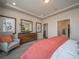 Comfortable bedroom showcases a chair, neutral tones, tray ceilings, and a view into the closet at 21935 E 51St Dr, Aurora, CO 80019