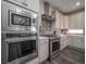 Modern kitchen with stainless steel appliances, gray cabinetry, tile backsplash, and wood flooring at 21935 E 51St Dr, Aurora, CO 80019