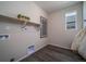Well-lit laundry room features hardwood floor, convenient shelving, and modern utility connections at 21935 E 51St Dr, Aurora, CO 80019