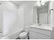 Bright bathroom featuring a tub-shower combo with white tiling and a modern vanity with ample storage space at 453 Interlocken Blvd # 104, Broomfield, CO 80021