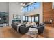 Sunlit living room with floor-to-ceiling windows, fireplace, and stylish modern furnishings at 651 Emberglow Ln, Highlands Ranch, CO 80126