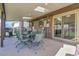 Comfortable covered patio with seating, a grill, and sliding glass door into the brick home at 4381 S Estes St, Littleton, CO 80123