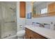 Bright bathroom with a glass enclosed shower, vanity sink, and wood cabinets at 4381 S Estes St, Littleton, CO 80123
