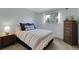 Comfortable bedroom with a plush bed, side tables, chest of drawers, and a window with a view at 4381 S Estes St, Littleton, CO 80123