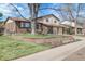 Charming two-story home with brick accents, landscaped yard, and mature trees under a beautiful blue sky at 4381 S Estes St, Littleton, CO 80123