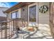 Inviting front porch featuring a white wreath, brick accents, and a cozy seating area at 4381 S Estes St, Littleton, CO 80123