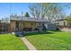 Exterior view of the backyard, with a grill, patio, shed, and large grassy area at 4530 S Pennsylvania St, Englewood, CO 80113
