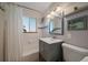 Bathroom featuring tiled walls, a shower and bathtub, and a modern vanity with storage at 4530 S Pennsylvania St, Englewood, CO 80113
