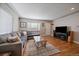 Cozy living room with a comfortable sectional sofa, hardwood floors, and ample natural light from the window at 4530 S Pennsylvania St, Englewood, CO 80113