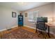 Office/bedroom space features hardwood floors, a desk, and a stylish blue bookshelf at 4530 S Pennsylvania St, Englewood, CO 80113