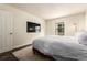 Bedroom with a large bed, a TV, a bright window, and a plush rug, perfect for relaxation and entertainment at 12047 E Harvard Ave # 103, Aurora, CO 80014