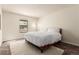 Bright bedroom featuring a large bed, a window for natural light, and a cozy rug on the floor at 12047 E Harvard Ave # 103, Aurora, CO 80014