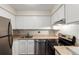 Efficient kitchen with stainless steel appliances and ample white cabinet storage at 12047 E Harvard Ave # 103, Aurora, CO 80014