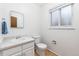 Well-lit bathroom with a vanity sink, toilet, and window provides a clean and functional space at 5819 W Milan Pl, Denver, CO 80235