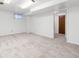 This is a carpeted bedroom with neutral colors, natural light and a wooden door at 5819 W Milan Pl, Denver, CO 80235