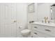Charming powder room with white vanity, gold fixtures, framed artwork, and a decorative mirror at 5926 S Jellison St # B, Littleton, CO 80123
