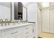 Bright bathroom features a double vanity with white cabinets, gold hardware, and black framed mirrors at 5926 S Jellison St # B, Littleton, CO 80123