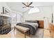 Comfortable bedroom featuring a wood fireplace, ceiling fan, and natural light from large windows at 5926 S Jellison St # B, Littleton, CO 80123